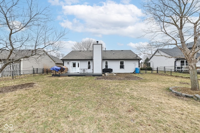 back of house featuring a lawn and a deck