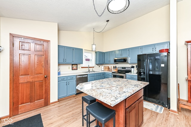 kitchen with sink, appliances with stainless steel finishes, a kitchen breakfast bar, and blue cabinets