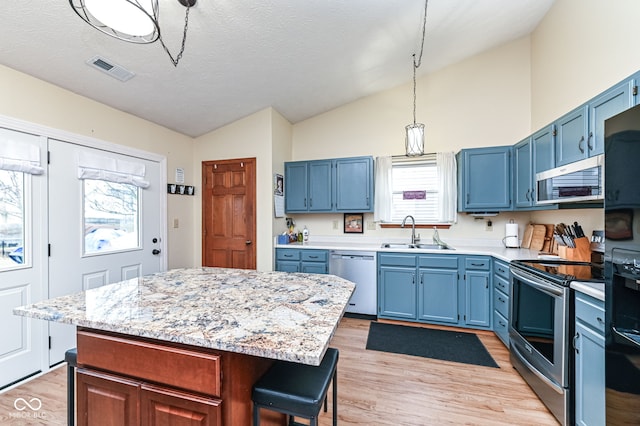 kitchen featuring a center island, blue cabinets, stainless steel appliances, and sink