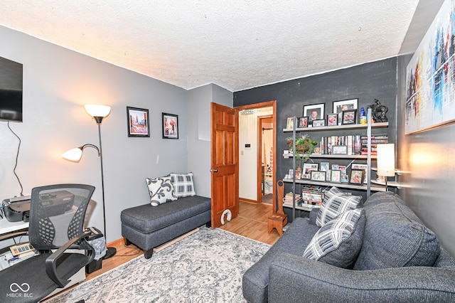 living room with light hardwood / wood-style floors and a textured ceiling