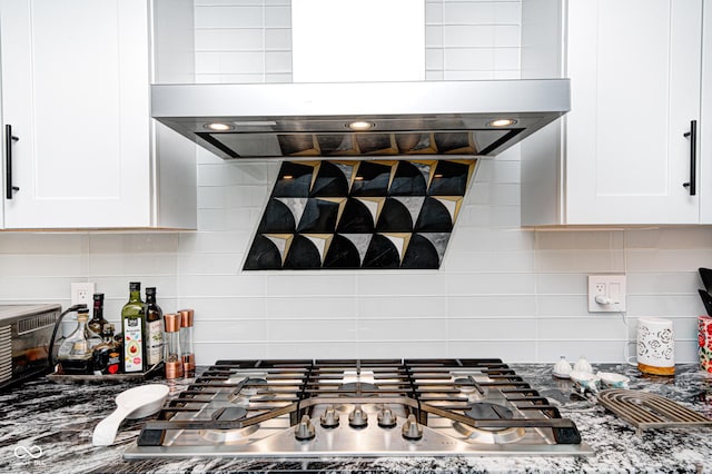 kitchen featuring stainless steel gas stovetop, tasteful backsplash, white cabinets, and island range hood