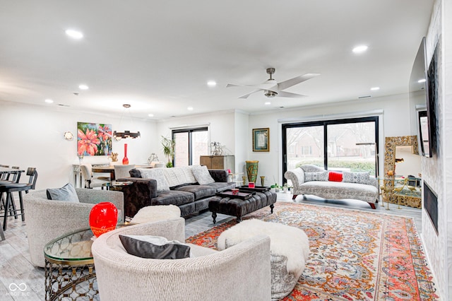 living room featuring ceiling fan, ornamental molding, light wood-type flooring, and recessed lighting