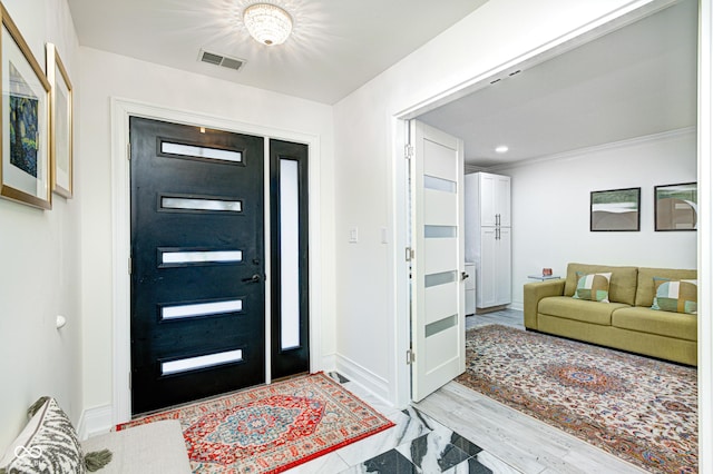 foyer entrance with light wood-type flooring, visible vents, and baseboards