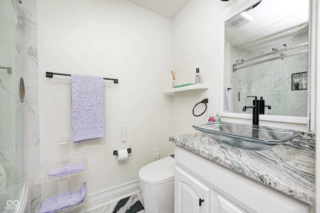 bathroom with toilet, vanity, visible vents, baseboards, and a marble finish shower