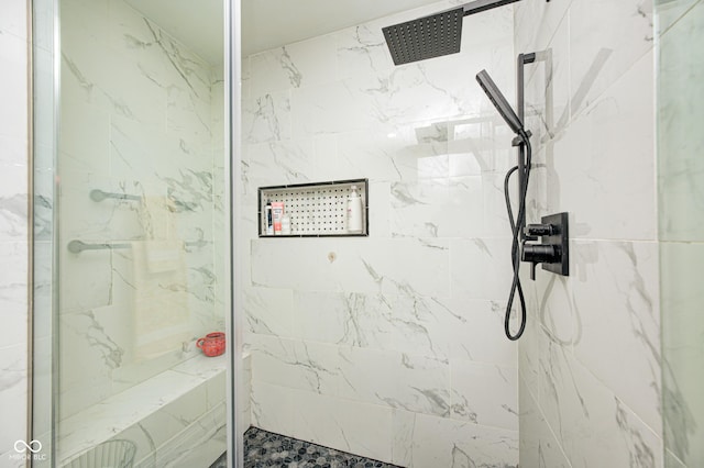 bathroom featuring a marble finish shower