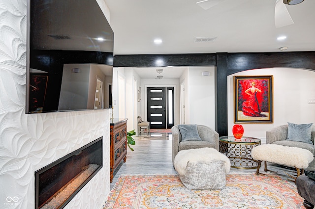 living room with light wood-style floors, recessed lighting, visible vents, and a fireplace