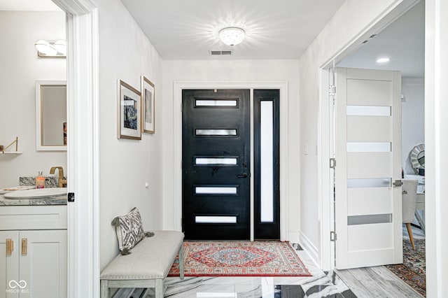 entrance foyer with light wood-style floors and visible vents