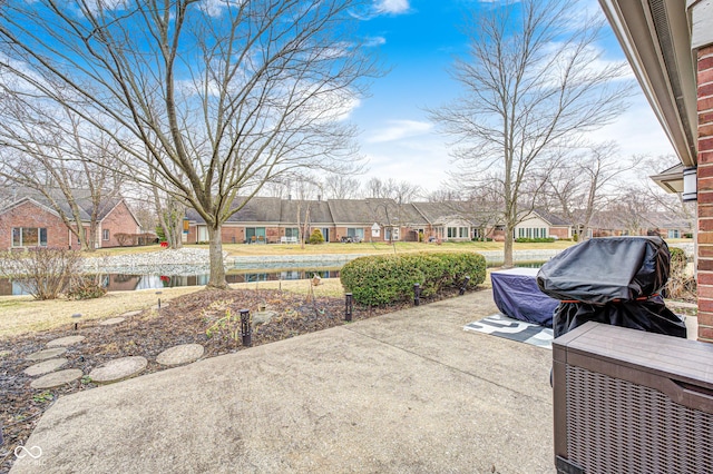 view of patio / terrace with a water view, a residential view, and area for grilling