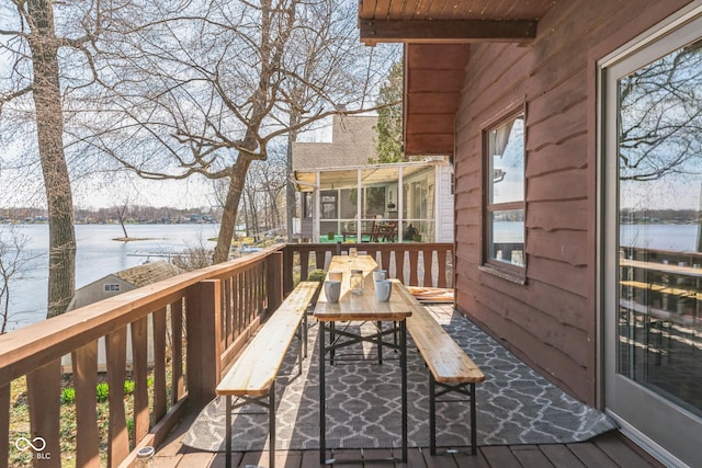 wooden terrace with a water view and a sunroom