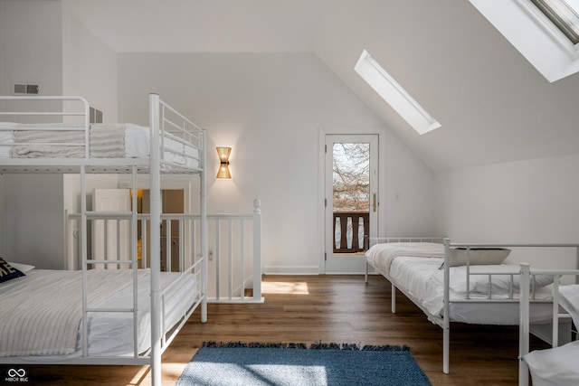 bedroom with lofted ceiling with skylight, dark hardwood / wood-style flooring, and access to outside