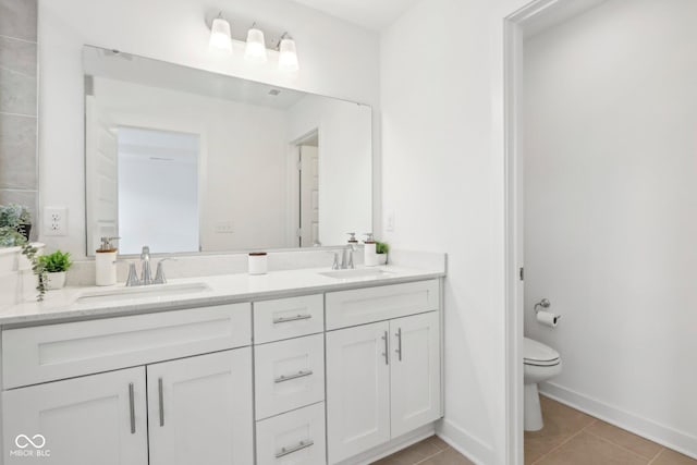 bathroom featuring vanity, tile patterned flooring, and toilet