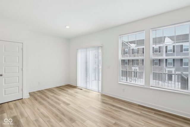 unfurnished room featuring light hardwood / wood-style floors and a wealth of natural light