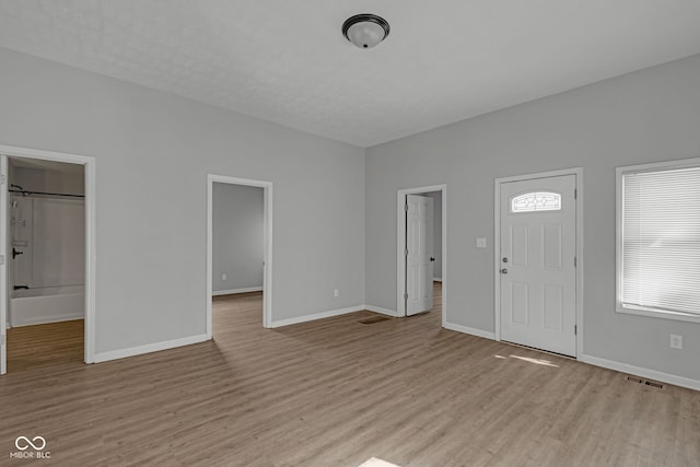 entryway with baseboards and light wood-style flooring