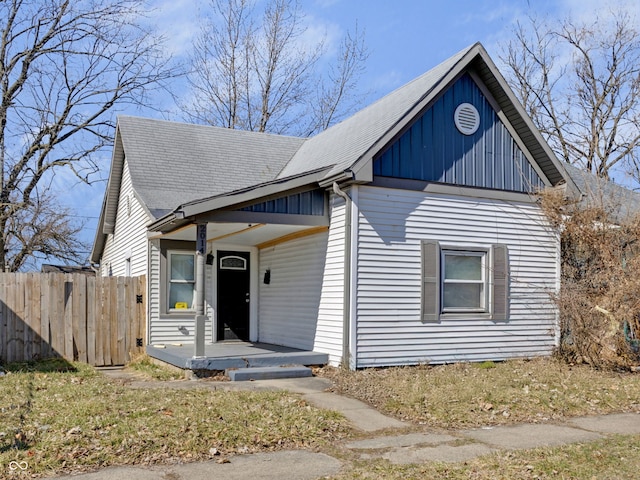 view of front of property featuring fence, board and batten siding, and roof with shingles