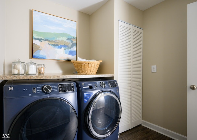 clothes washing area with dark wood-style flooring, laundry area, independent washer and dryer, and baseboards