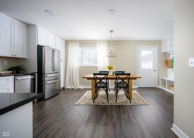 dining space featuring dark wood-style floors and baseboards