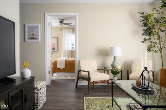 sitting room featuring dark wood-type flooring and ceiling fan