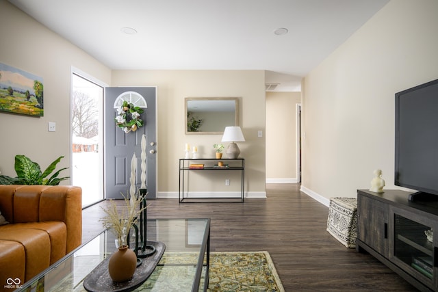 living room with dark wood finished floors, visible vents, and baseboards