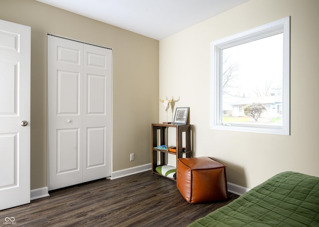 bedroom featuring dark wood-style floors, baseboards, and a closet