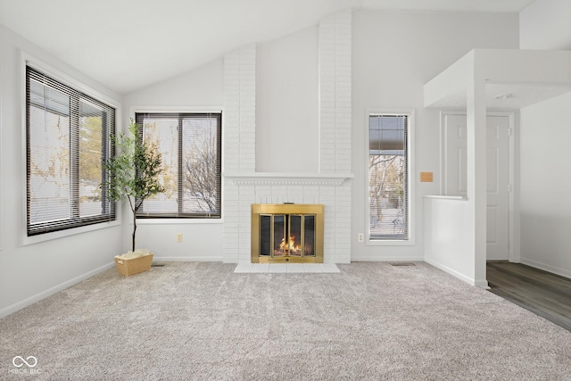 unfurnished living room featuring a brick fireplace, carpet, and vaulted ceiling