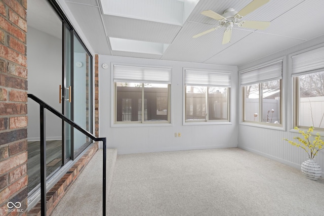 unfurnished sunroom featuring ceiling fan