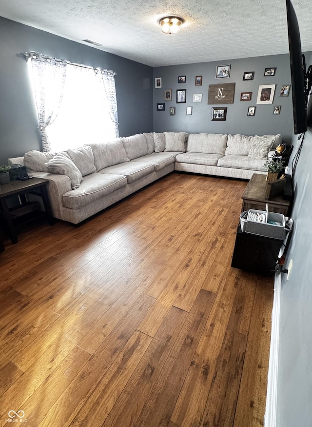 living room with hardwood / wood-style floors and a textured ceiling