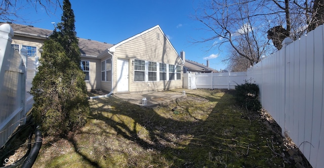 rear view of house featuring a patio and a fenced backyard