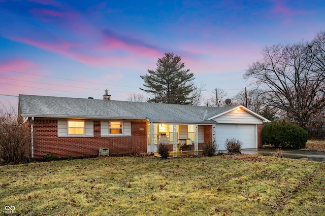 single story home with brick siding, a yard, a chimney, an attached garage, and driveway