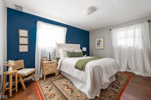 bedroom with dark wood-style floors and visible vents