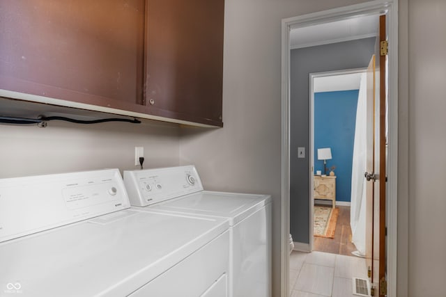 laundry area featuring cabinet space, visible vents, baseboards, crown molding, and washing machine and dryer