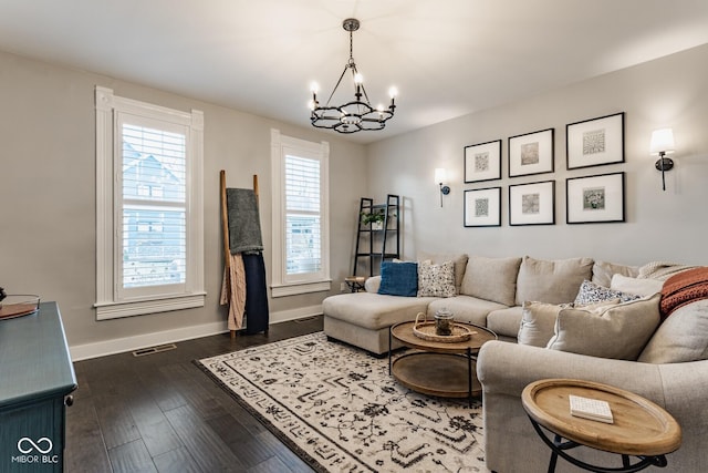 living area with dark wood-style floors, a chandelier, visible vents, and baseboards