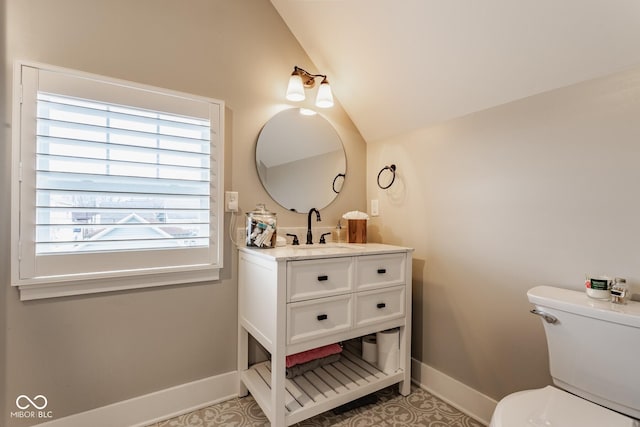 bathroom featuring toilet, baseboards, vaulted ceiling, and vanity