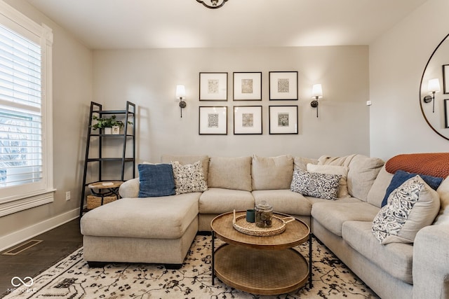 living room featuring baseboards, visible vents, and wood finished floors