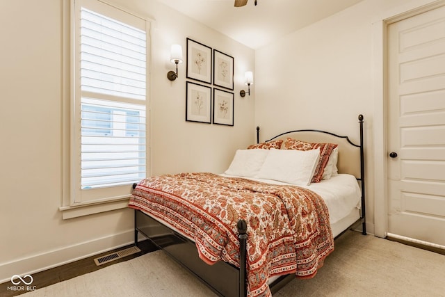 bedroom featuring a ceiling fan, visible vents, and baseboards