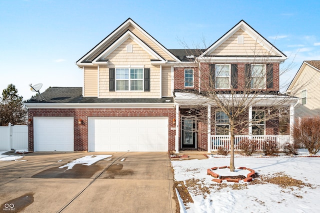 view of front of property featuring brick siding, a porch, concrete driveway, and fence