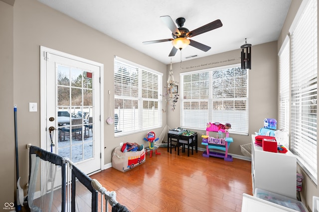 recreation room with ceiling fan and wood-type flooring