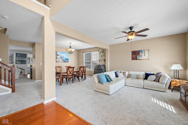 living room featuring hardwood / wood-style flooring and ceiling fan with notable chandelier