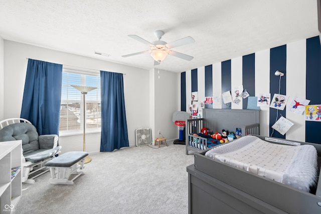 carpeted bedroom featuring a textured ceiling and ceiling fan