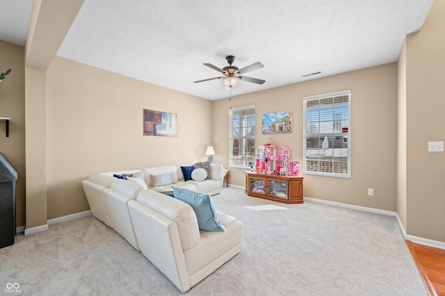 living room featuring a textured ceiling, light carpet, and ceiling fan