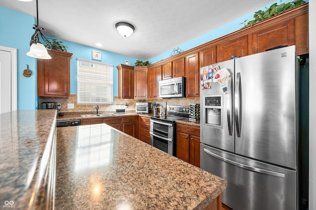 kitchen with sink, dark stone counters, decorative light fixtures, stainless steel appliances, and decorative backsplash