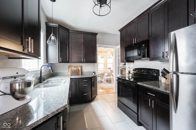 kitchen with sink, light stone counters, pendant lighting, black appliances, and dark brown cabinets