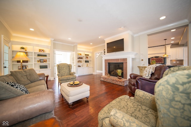 living area with dark wood finished floors, recessed lighting, a brick fireplace, and crown molding