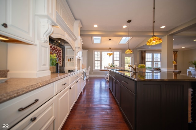 kitchen featuring recessed lighting, a skylight, white cabinets, black electric cooktop, and dark wood-style flooring