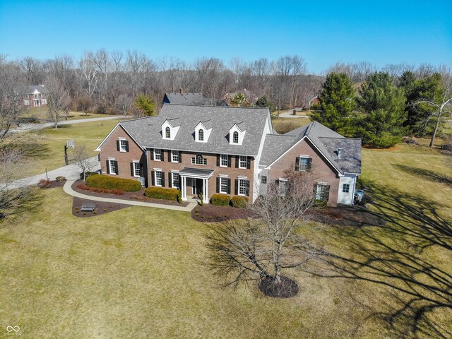 georgian-style home featuring a front yard