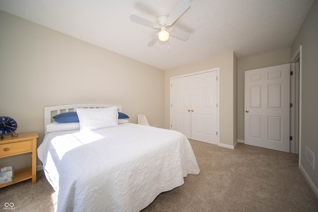 carpeted bedroom with a closet, baseboards, and a ceiling fan