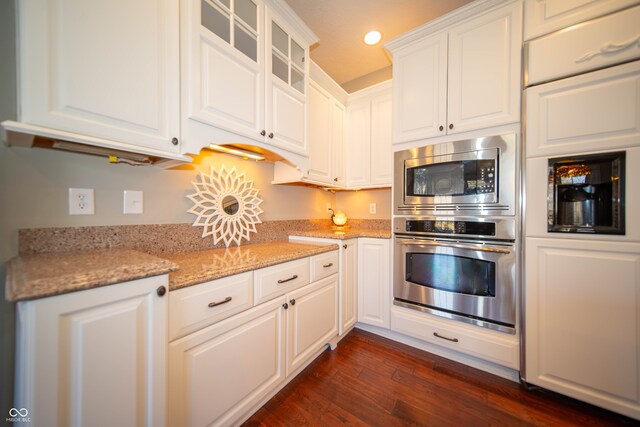 kitchen featuring light stone countertops, white cabinetry, glass insert cabinets, and dark wood-style flooring