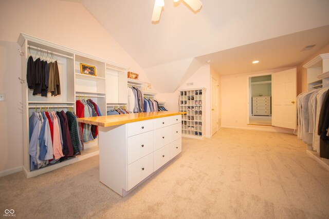 walk in closet with lofted ceiling, light colored carpet, and ceiling fan