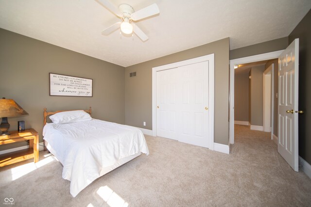 bedroom with visible vents, a closet, carpet floors, baseboards, and ceiling fan