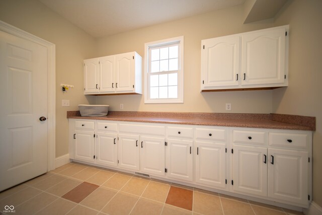 kitchen featuring light tile patterned floors and white cabinets