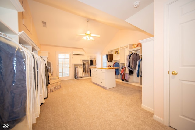 spacious closet with lofted ceiling, light colored carpet, an AC wall unit, and ceiling fan